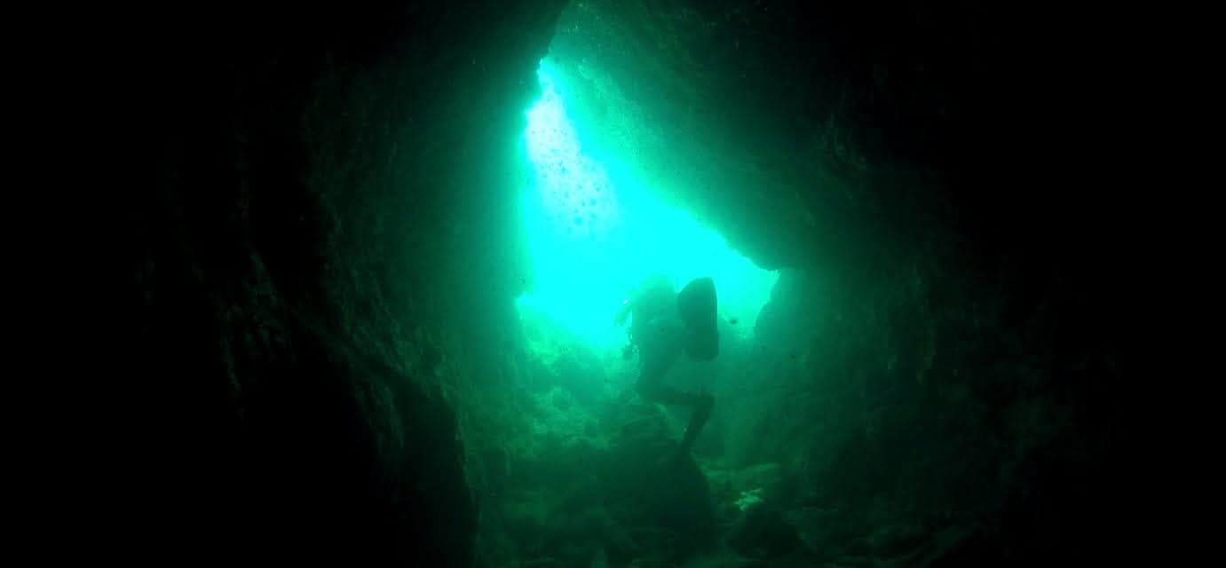 Green light glowing through an underwater sea cave